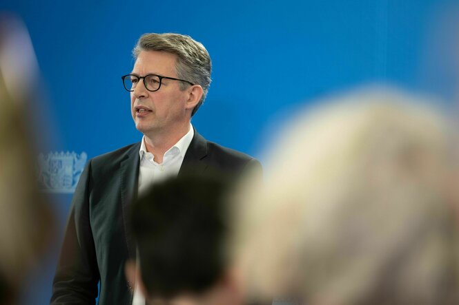 Bayerns Kunstminister Markus Blume (CSU) nimmt an einer Pressekonferenz teil, durch das Publikum gesehen