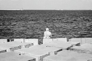 Eine Frau sitz am Meer