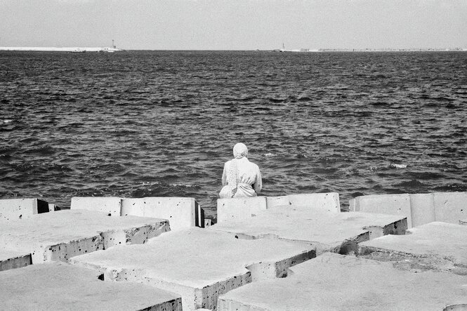Eine Frau sitz am Meer