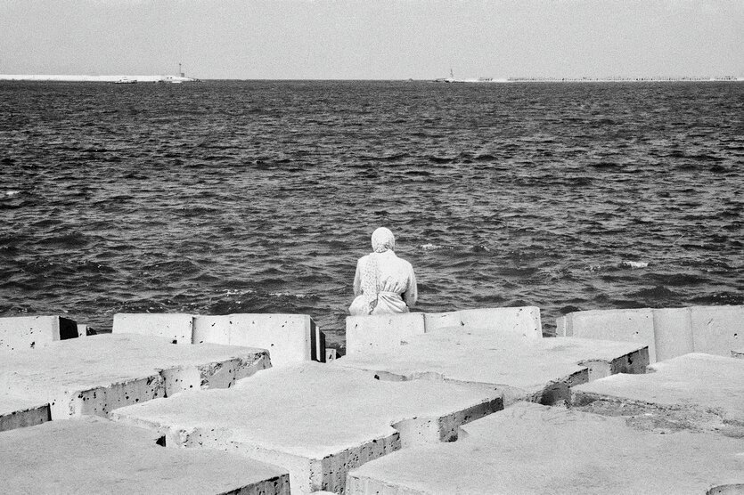 Eine Frau sitz am Meer