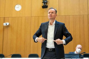 Der angeklagte frühere Vorstandschef von wirecard, Markus Braun (l), steht im Gerichtssaal, während im Hintergrund der Mitangeklagte und Kronzeuge im wirecard-Prozess, Oliver Bellenhaus, sitzt