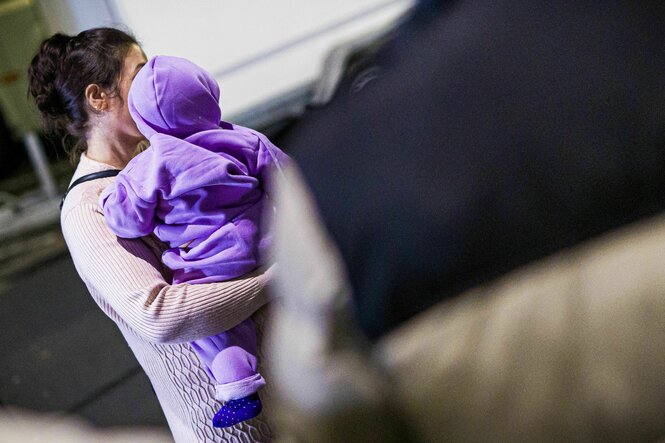 Eine Mutter aus Afghanistan, die zuvor mit ihrem Kind in einem Flugzeug auf dem Flughafen Hannover-Langenhagen gelandet ist, steht vor dem Flughafen