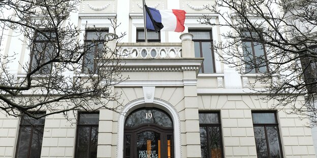 Über der Eingangstür des Institut Français weht die fanzösische Flagge mit einer schwarzen Fahne auf Halbmast.
