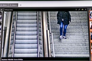 Das Foto zeigt einen Computerbildschirm, auf dem ein Mensch zu sehen ist, der am Berliner Bahnhof Südkreuz eine Treppe hinab geht
