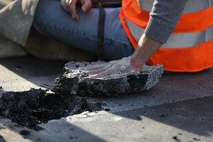 Polizisten lösen einen angeklebten Aktivisten von der Straße