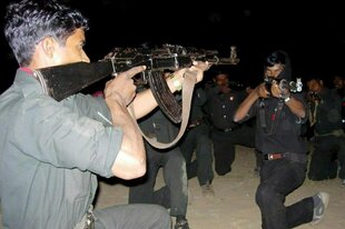 Junge Männer mit Gewehren in der Dunkelheit