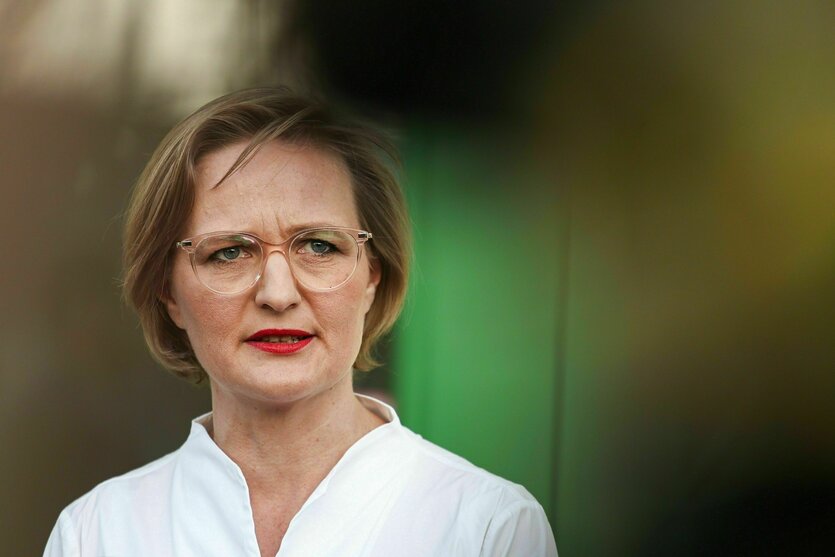 Eine Frau mit Brille und weißer Bluse schaut kritisch