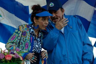 Ein Mann flüstert einer Frau etwas ins Ohr