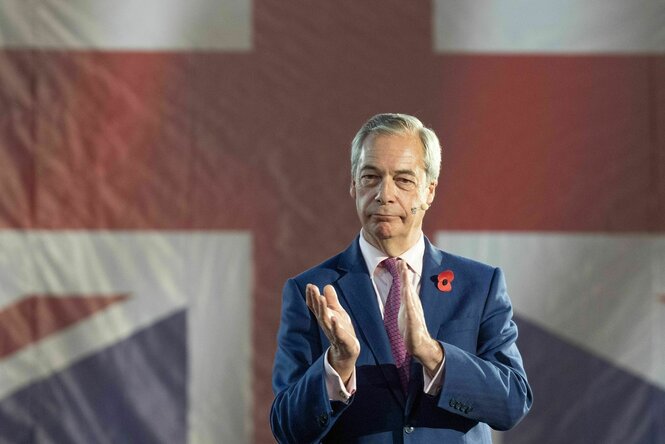Nigel Farage klatschend vor einer britischen Fahne