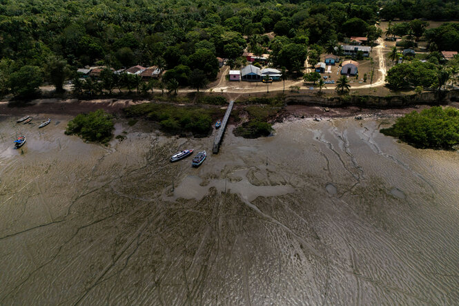 Ein Dorf an einem Fluss mit Mangrovenwäldern.