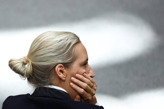 Eine Frau stützt ihr Gesicht auf ihre rechte Hand