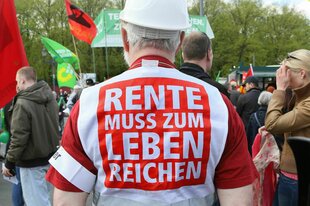 Ein Demonstrant mit Rente muss zum Leben reichen Aufschrift.