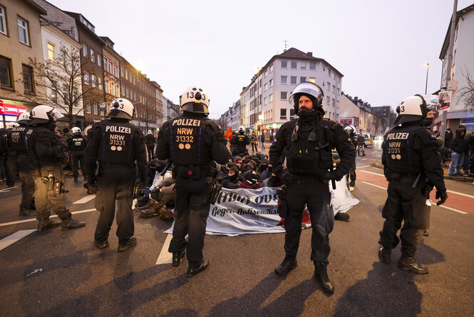 Bereitschaftspolizist*innen stehen auf der Straße um eine Sitzblockade gegen eine Nazidemo in Aachen