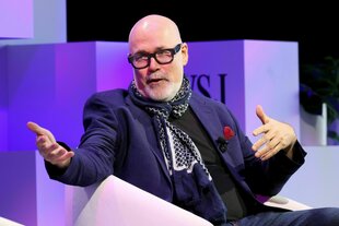 Ein Mann mit Brille gestikuliert mit seinen Händen