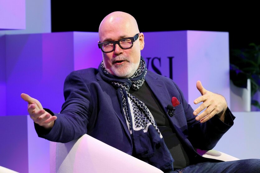 Ein Mann mit Brille gestikuliert mit seinen Händen