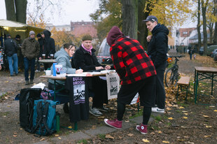 Verschiedene Personen unterhalten sich an einem Info-Stand
