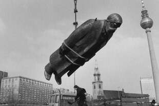 Das Standbild von Friedrich Engels hängt an einem Seil, im Hintergrund ist der Ostberliner Fernsehturm zu sehen