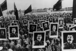 EIn von 1949 datiertes Schwarz-weiß-Foto von Mitgliedern der „Kommunistischen Partei Chinas“, die den Geburstag von Josef Stalin feiern. Viele halten ein großes Portraitfoto von ihm hoch.