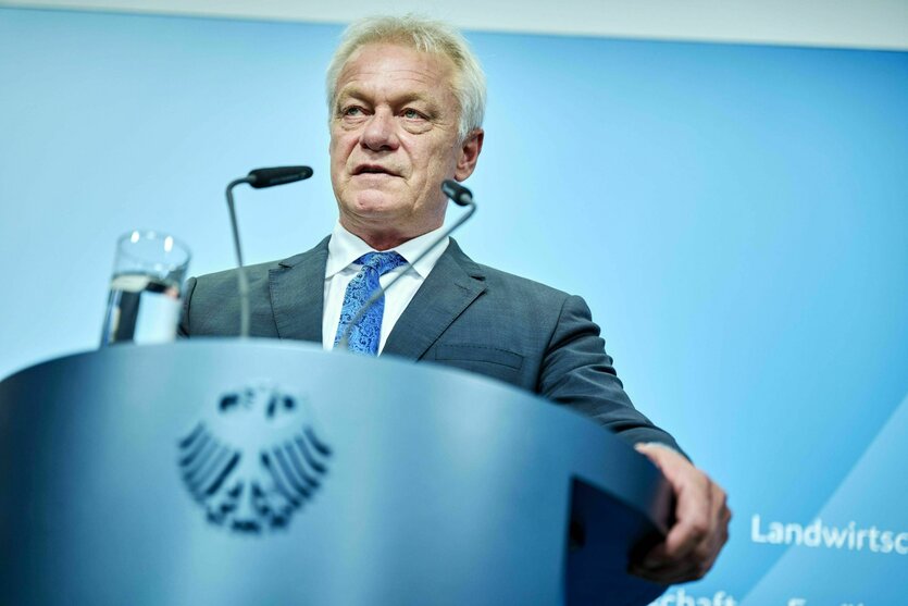 Ein Mann im Anzug steht an einem Rednerpult und spricht ins Mikrofon