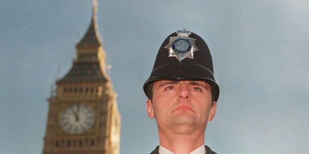 Ein behelmter britischer Polizist vor einem Turm