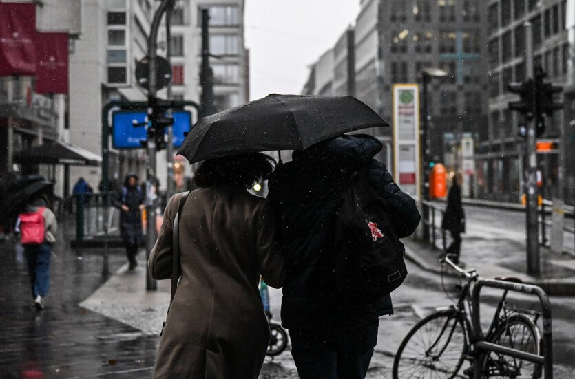 Menschen mit Regenschirm auf Straße