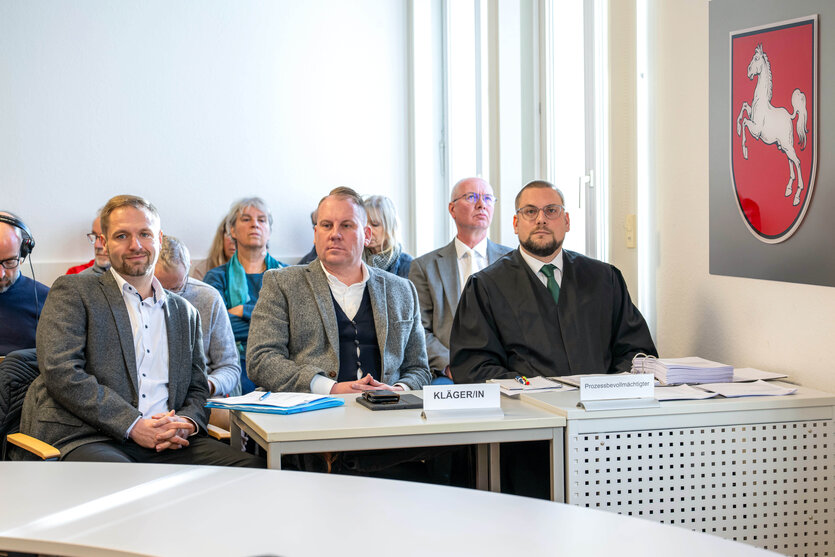 Drei Männer sitzen in einem Gerichtssaal des Verwaltungsgerichts Oldenburg