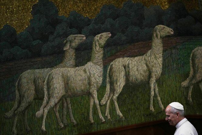 Der Papst im Vordergrund, im Hintergrund ein großes Bild mit Schafen auf einer Wiese