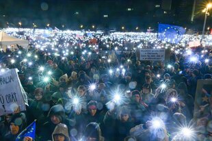 Viele Menschen mit Lichtern bei einer Demonstration.