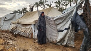 Porträt von Khawla Khadr vor ihrem Zelt in einem Flüchtlingslager.