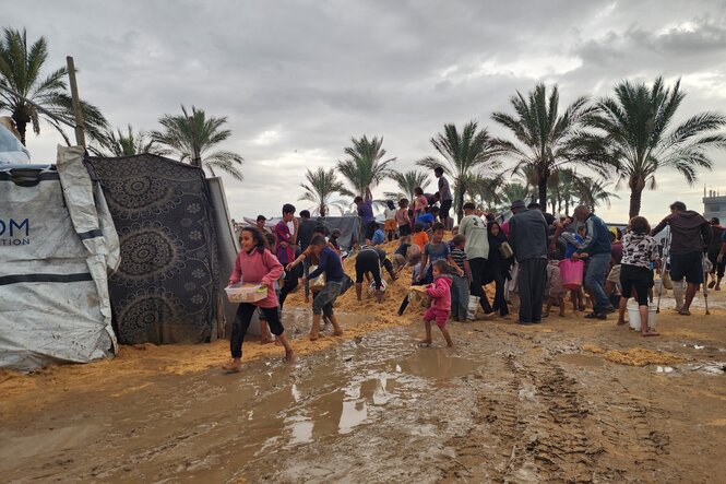 Verschlammte Wege in einem Flüchtlingslager mit Zelten.