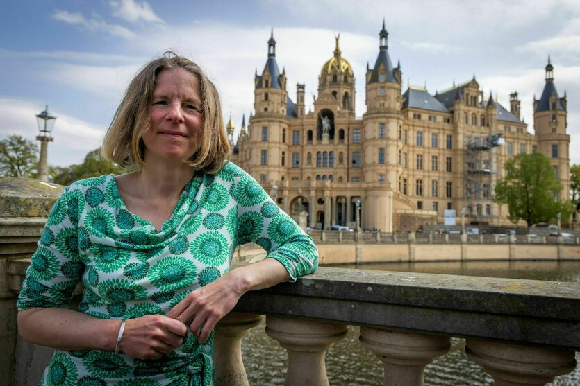 Eine Frau leht sich an ein Geländer