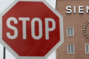 Ein Stopp-Schild, dahinter die Siemens-Zentrale in Erlangen