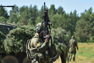 Bundeswehr-Infanterist vor einem Schützenpanzer „Marder“ der Bundeswehr während einer Übung