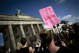 Protestierende mit Schild, auf dem steht: "Wir halten mit Liebe dagegen", bei einer Demonstation