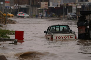 Auto halb versunken in einer überfluteten Straße