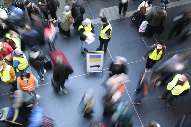 Ankommende Menschen an einem Bahnhof.