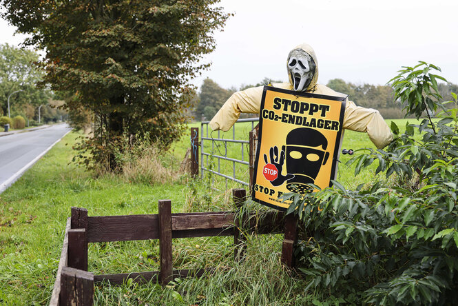Ein Protest-Plakat steht am Straßenrand.