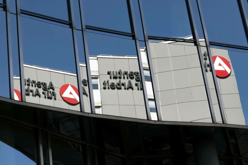 Ein Gebäude der Agentur für Arbeit spiegelt sich in einer Fensterfront