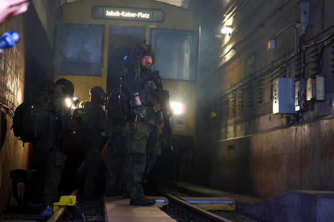 Soldaten stehen auf einem Gleisbett vor einer U-Bahn