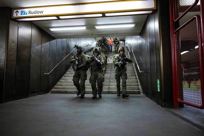 Bewaffnete Soldaten der Bundeswehr kommen eine Treppe im U-Bahnhof Jungfernheide runtergelaufen