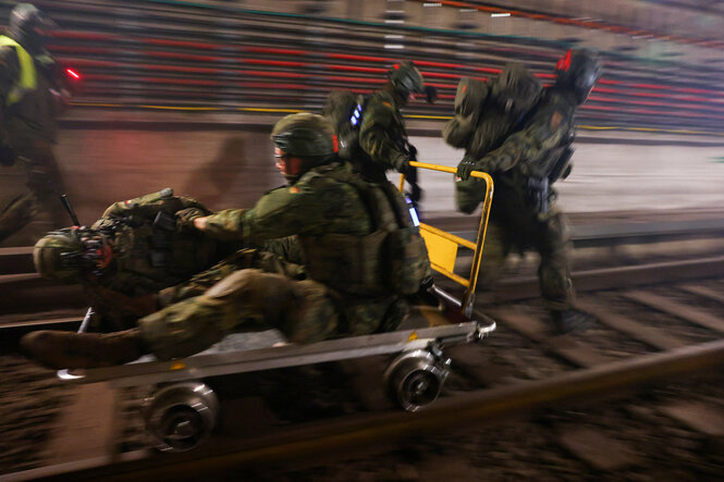 Ein verletzter Soldat wird auf einem Trolley die Schienen entlang gezogen
