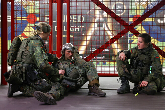 Verletzte Soldaten sitzen auf dem Boden eines Bahnsteigs
