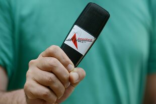 Eine Person hält ein Mikrofon in der Hand