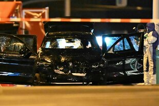 Ein schwarzes Autowrack hinter Absperrungsband