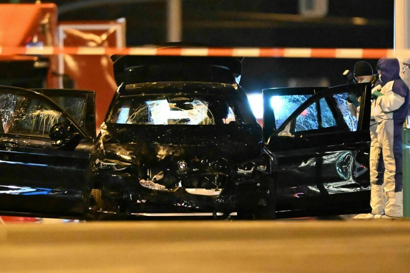 Ein schwarzes Autowrack hinter Absperrungsband