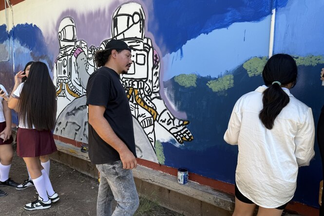 Jugendliche mit Dos de Buche an einer Grafitti-Wand.