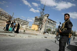 Syrischer Soldat steht Wache, während Bewohner die Stadtteile Sheikh Maqsoud und Achrafieh von Aleppo verlassen