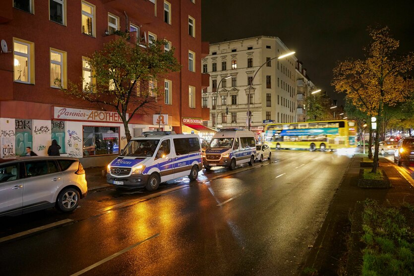 eine Berliner Straße im Dunkeln mit Polizeiautos