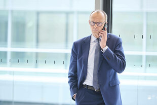 Friedirch Merz hält ein Smartphone ans Ohr