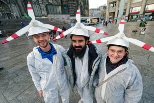 Drei Personen haben sich als Windräder verkleidet